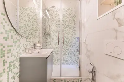 a white bathroom with a shower and a sink at Vatican Chic House II in Rome