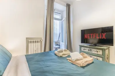 a bedroom with a bed with a television and towels at Vatican Chic House II in Rome