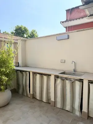 a outdoor kitchen with a sink and a counter at Spacious Apartment with Outdoor Terrace near Vatican - Casa Vacanze Romane in Rome