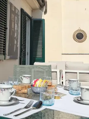 a table with plates and cups on top of it at Spacious Apartment with Outdoor Terrace near Vatican - Casa Vacanze Romane in Rome