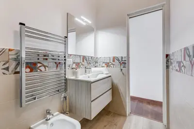 a white bathroom with a sink and a mirror at 5 min Piazza Navona-Aria Condizionata-Smart TV-Cucina completa in Rome
