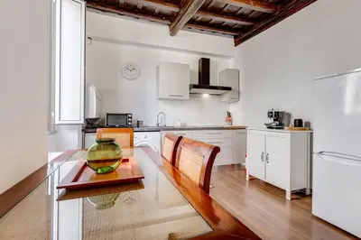 a kitchen with a glass bowl on a wooden table at 5 min Piazza Navona-Aria Condizionata-Smart TV-Cucina completa in Rome