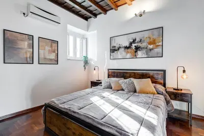 a bedroom with a large bed and white walls at 5 min Piazza Navona-Aria Condizionata-Smart TV-Cucina completa in Rome