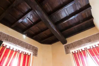 a room with wooden ceilings and windows with red curtains at Domus Trevi in Rome