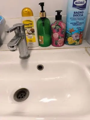 a bathroom sink with two bottles of detergent and soap at Qiyuan Hotel in Rome