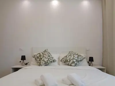 a bedroom with a white bed with two pillows at Jumbo Inn in Rome