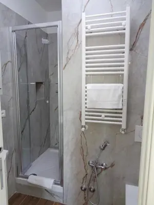 a bathroom with a shower with a glass door at Jumbo Inn in Rome