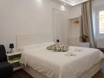 a bedroom with a white bed with towels on it at Jumbo Inn in Rome