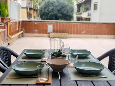 a wooden table with green bowls and plates on it at Via Lattea Vatican Apartment - Family friendly in Rome