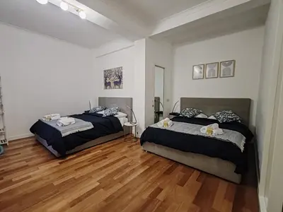 two beds in a room with wooden floors at Via Lattea Vatican Apartment - Family friendly in Rome