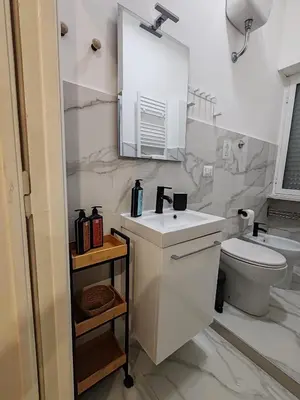 a white bathroom with a sink and a toilet at Via Lattea Vatican Apartment - Family friendly in Rome