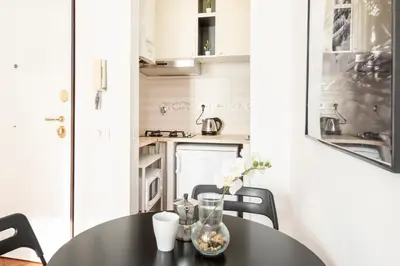 a dining room table with a vase of flowers on it at White Flat Termini in Rome