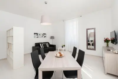 a white living room with a wooden table and chairs at White Flat Termini in Rome
