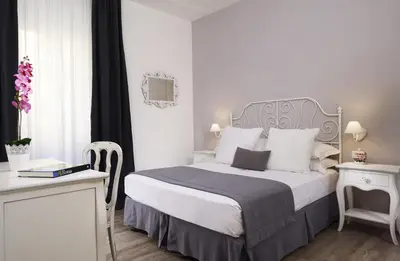 a bedroom with a large bed and a table and a desk at Vaticano Charming Rooms in Rome
