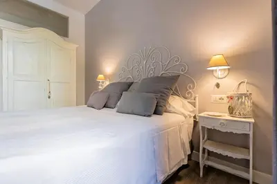 a bedroom with a large white bed with two lamps at Vaticano Charming Rooms in Rome