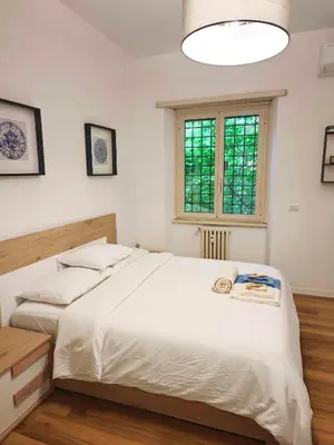 a bedroom with a large white bed and a window at DOMUS Villa Chigi in Rome