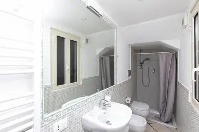 a bathroom with a sink and a toilet and a mirror at San Pietro Terrace Apartment in Rome