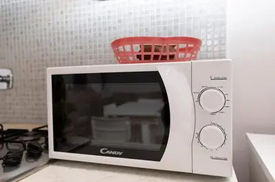 a microwave with a red basket on top of it at San Pietro Terrace Apartment in Rome