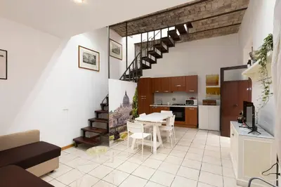 a kitchen and living room with a staircase in a room at San Pietro Terrace Apartment in Rome