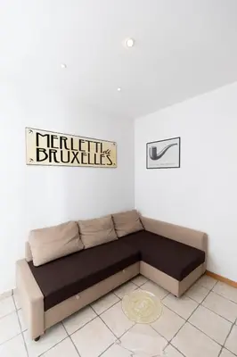 a couch in a room with a sign on the wall at San Pietro Terrace Apartment in Rome