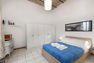 a bedroom with a blue bed and white cabinets at San Pietro Terrace Apartment in Rome
