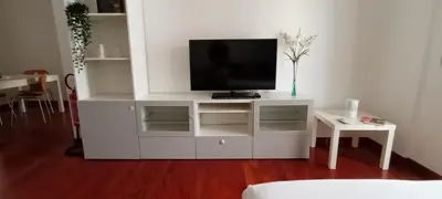 a white entertainment center with a flat screen tv on it at Leila Stazione Tiburtina 10 minuti dal Coloseo in Rome