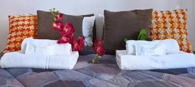 a bed with white towels and red flowers on it at Leila Stazione Tiburtina 10 minuti dal Coloseo in Rome