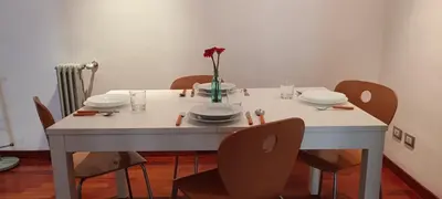 a white table with chairs and a vase of flowers on it at Leila Stazione Tiburtina 10 minuti dal Coloseo in Rome