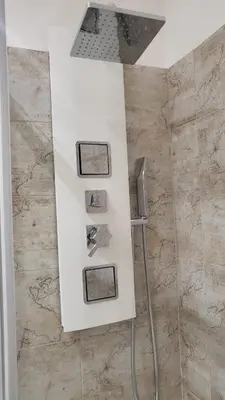 a bathroom with a white counter with four pictures at A casa di Tommy in Rome