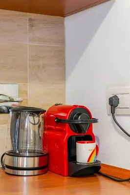 a red coffee maker sitting on top of a counter at Artistic colorful Apart Vatican Museums in Rome