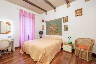 a bedroom with a bed and a painting on the wall at Artistic colorful Apart Vatican Museums in Rome