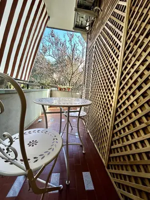 two tables and a chair on a balcony at Da Elisa e Davide House in Rome
