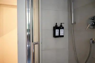 a bathroom with a shower with two bottles on the wall at Appiano Garden Apartment in Rome
