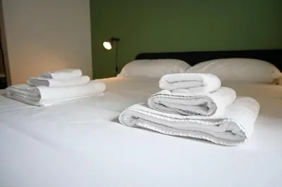 a pile of towels sitting on top of a bed at Appiano Garden Apartment in Rome