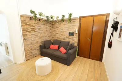 a living room with a couch and a brick wall at Appartamento Vaticano Metro A in Rome
