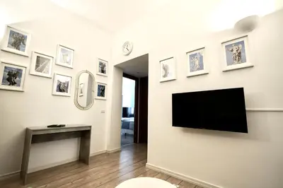 a living room with a television on a wall with pictures at Appartamento Vaticano Metro A in Rome