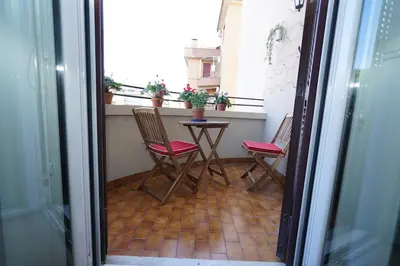 a balcony with two chairs and a table with plants at Appartamento Vaticano Metro A in Rome