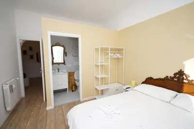 a white bedroom with a bed and a bathroom at Appartamento Vaticano Metro A in Rome