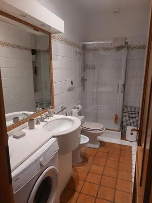 a bathroom with a toilet and a sink and a washing machine at Exclusive Flat Piazza di Spagna in Rome