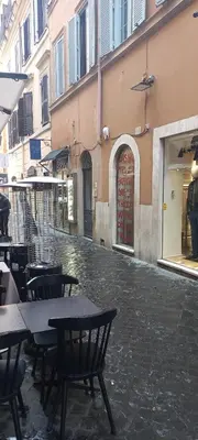 an empty street with tables and chairs next to a building at Exclusive Flat Piazza di Spagna in Rome
