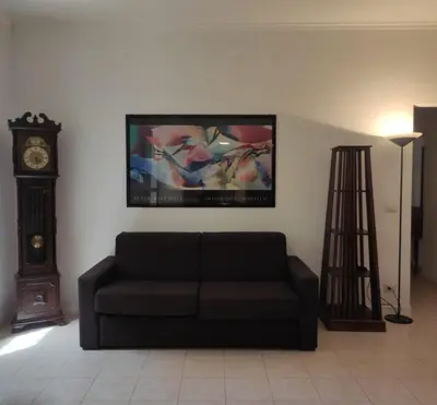 a living room with a couch and a clock at Fabio's Home Gemelli in Rome