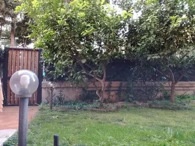 a fence in a yard with a tree and a pole at Fabio's Home Gemelli in Rome