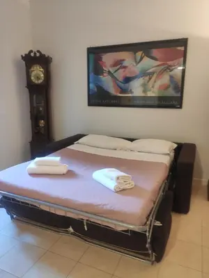 a bed in a room with a clock on the wall at Fabio's Home Gemelli in Rome