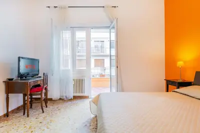 a bedroom with a bed and a desk with a television at 10 Minutes by Car from St Peter's Basilica in Rome
