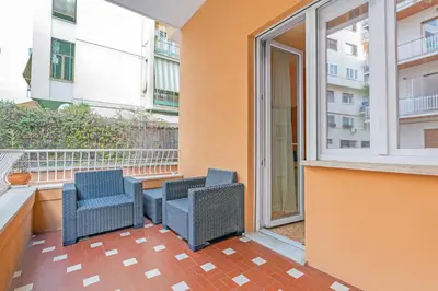 a balcony with three chairs and a window at 10 Minutes by Car from St Peter's Basilica in Rome