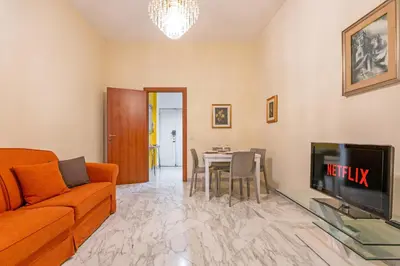 a living room with a couch and a tv and a table at 10 Minutes by Car from St Peter's Basilica in Rome