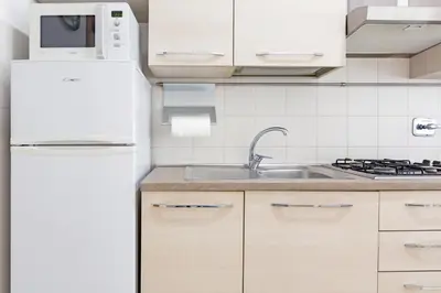 a kitchen with a white refrigerator and a sink at 10 Minutes by Car from St Peter's Basilica in Rome