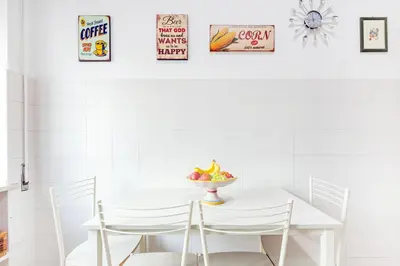 a white table and chairs with a bowl of fruit on it at 10 Minutes by Car from St Peter's Basilica in Rome