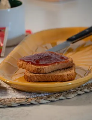 a piece of bread with jam on a yellow plate at Wood Apartment - Rome Battistini in Rome