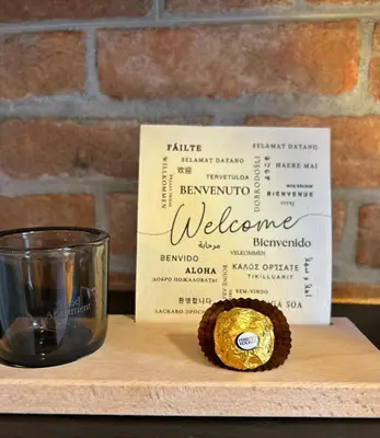 a sign and a cupcake next to a glass at Wood Apartment - Rome Battistini in Rome
